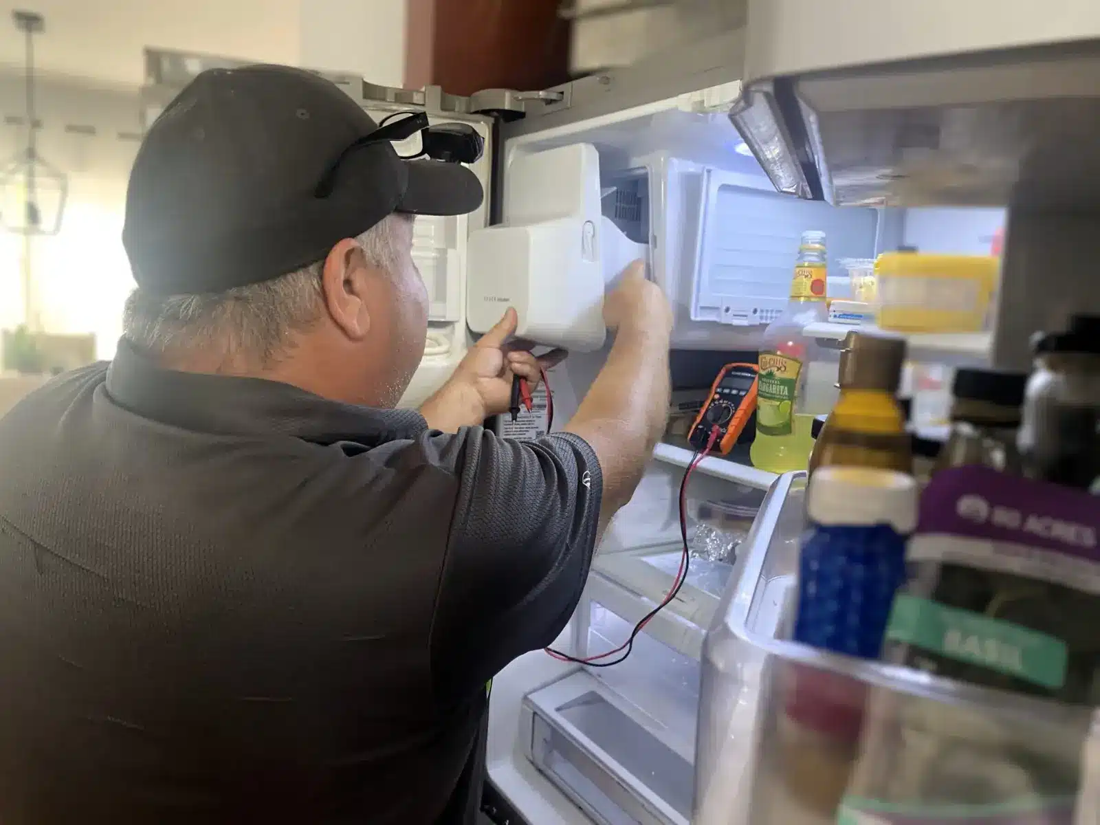 BA Appliance Repair technician diagnosing a refrigerator