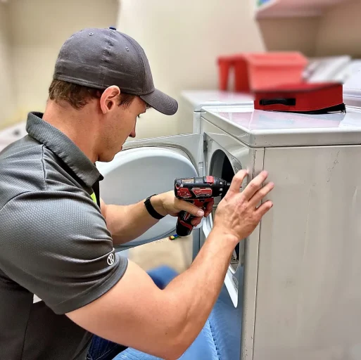 Adam Bigelow the CEO of BA Appliance Repair Service, Repairing a dryer in a laundry room.