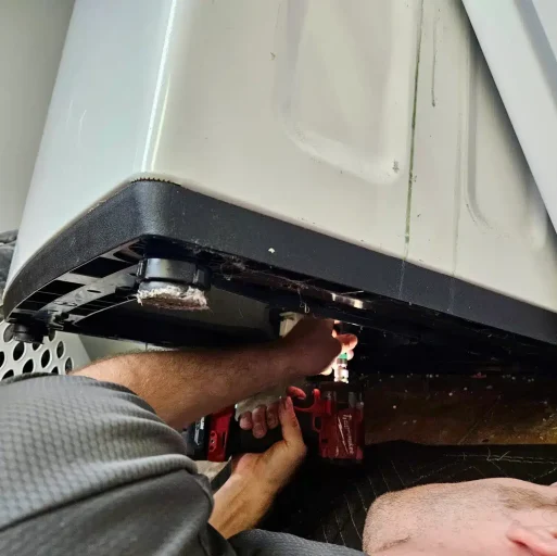 Skilled technician repairing a washing machine, highlighting the reliable washer repair services offered by BA Appliance Repair Service.